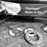 Ein schwarz-weißes Foto von Rettungsreifen. Auf dem Banner steht "Thüringer Bäder in Not"