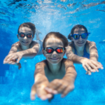 Kinder die im Wasser tauchen und lächeln