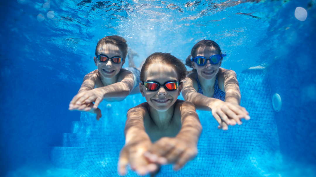Kinder die im Wasser tauchen und lächeln