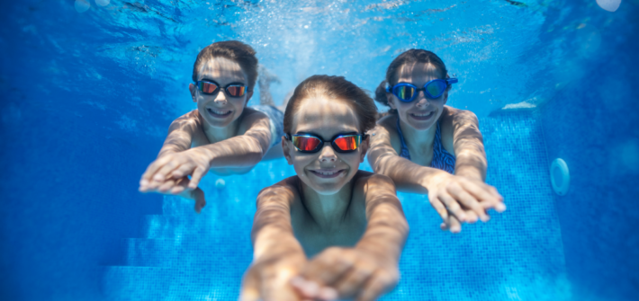 Kinder die im Wasser tauchen und lächeln